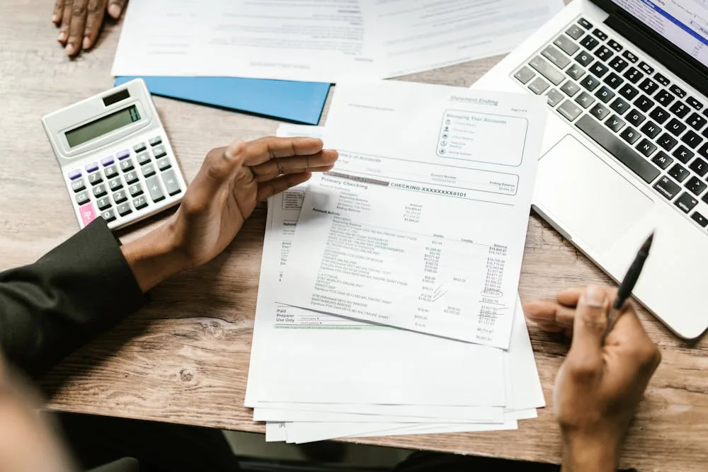 Hands reviewing bank statements and financial documents a debtor must produce at a NSW examination